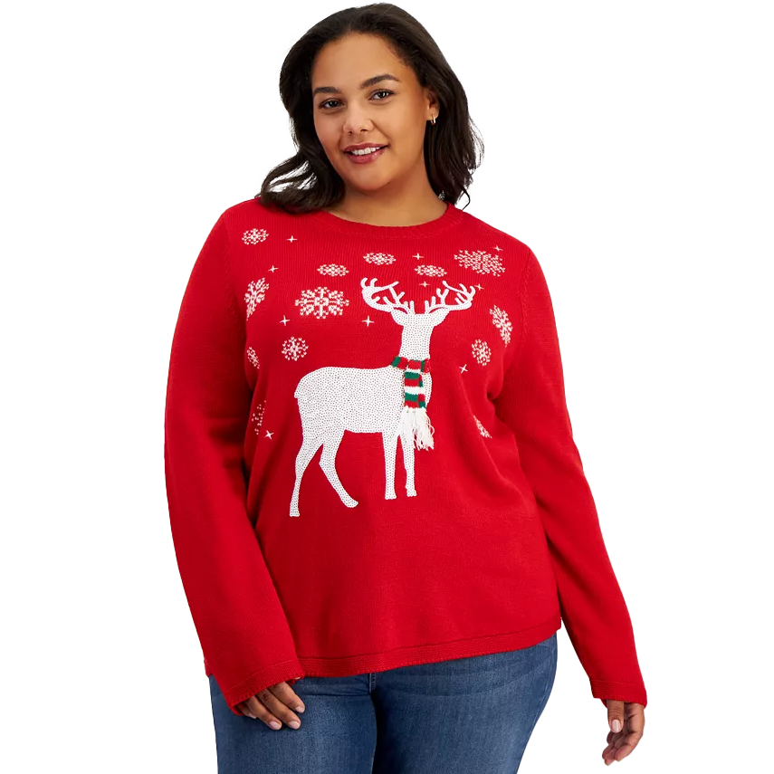 A woman is wearing a red holiday-themed sweater featuring a white reindeer pattern and decorative snowflakes.
