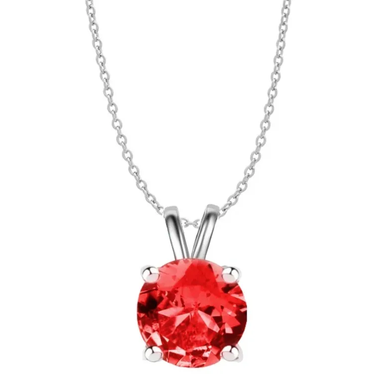 A silver chain necklace featuring a round, vibrant red created ruby gemstone set in a simple, elegant pendant setting with four prongs.