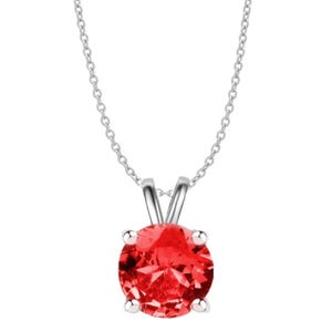 A silver chain necklace featuring a round, vibrant red created ruby gemstone set in a simple, elegant pendant setting with four prongs.
