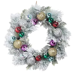 A decorative Christmas wreath featuring frosted pine branches, gold and silver glittery balls, and colorful ornaments in red, green, purple, and blue, accented with shimmering silver berries.