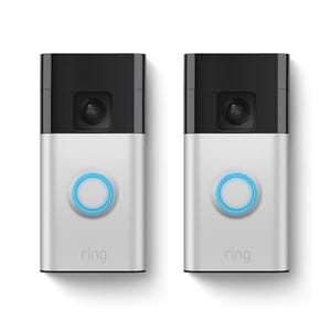 Two Ring Video Doorbells with black tops and silver bodies, each featuring a camera lens and an illuminated blue circular button below.