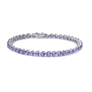 A bracelet featuring heart-cut created tanzanite stones set in a continuous line, mounted on a silver-toned metal base with a secure clasp.