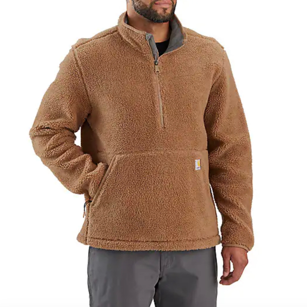 A brown sherpa fleece pullover with a quarter-zip design and a large front pocket, worn by a man with his hands in his pockets.