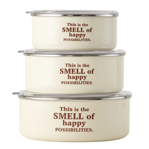 Three stacked, round cream-colored containers with clear lids, featuring the phrase \“This is the SMELL of happy POSSIBILITIES.\“