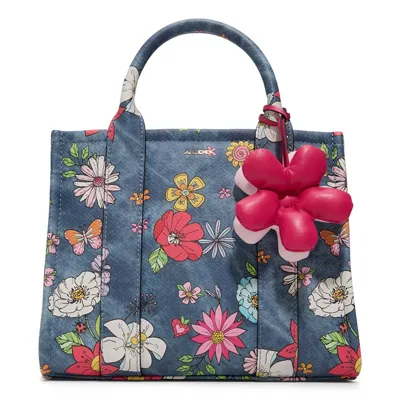 A floral-patterned tote bag with a denim-like texture, featuring a red flower charm hanging from the handle.