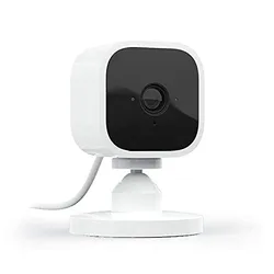 White and black compact security camera with a stand and cable.