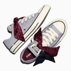 Blue and white striped sneakers with burgundy and navy polka dot ribbon laces, featuring a classic design and canvas upper.