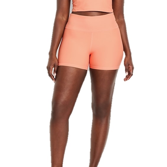 A person is wearing peach-colored high-waisted athletic shorts paired with a matching top.