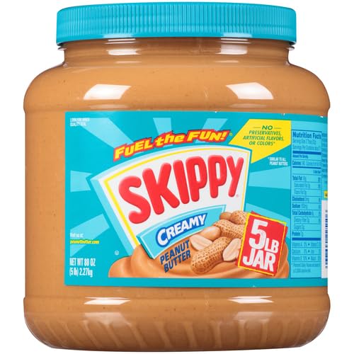 A large, 5-pound jar of Skippy Creamy Peanut Butter with a blue and orange label showcasing the brand and product type.