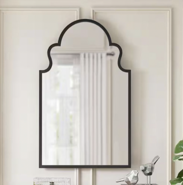 A decorative wall mirror with an arched top and a simple black frame.