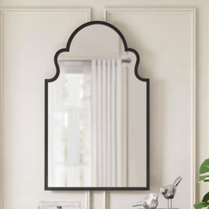 A decorative wall mirror with an arched top and a simple black frame.