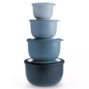 A stack of four nesting bowls with lids, in varying shades of blue, featuring a ribbed texture.