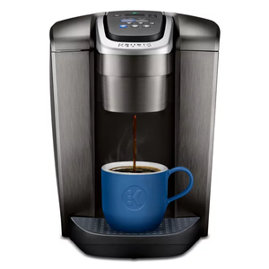 A Keurig K-Elite Coffee Maker is brewing coffee into a blue mug, featuring a digital control panel and a metallic finish.