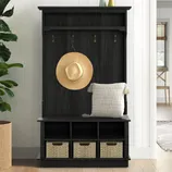 A dark wood entryway bench with a hat, cushion, and three wicker baskets underneath; it also features coat hooks and a small top shelf, ideal for organizing a hallway.