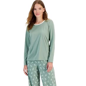 A two-piece pajama set featuring a sage green long-sleeve top with a white neckline and matching pants adorned with a subtle pattern of small white Christmas trees.