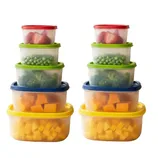 A stack of colorful, plastic food storage containers with lids, containing strawberries, green peas, broccoli, and cubed cheese. The containers are arranged in two identical stacks.