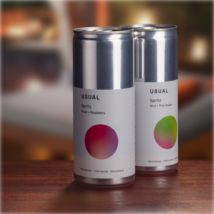 Two cans of Usual Spritz, one flavored Rosé + Raspberry and the other Brut + Pink Guava, both containing wine spritzers with an alcohol content of 7-8%.