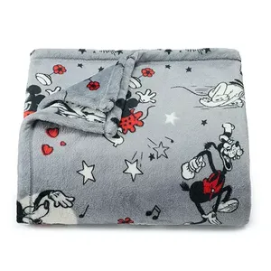 A plush Disney throw featuring classic characters like Mickey Mouse in a playful black, white, and red design against a gray background.
