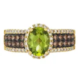 Gold ring featuring an oval green gemstone centerpiece, flanked by rows of brown and clear stones in a stacked pattern.