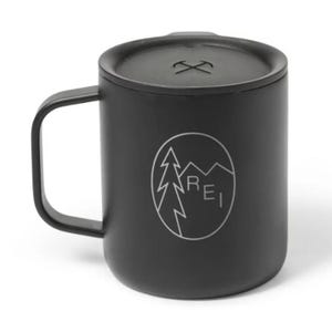 Black camping mug with a lid, featuring a tree and mountain design along with the text \“REI\“.