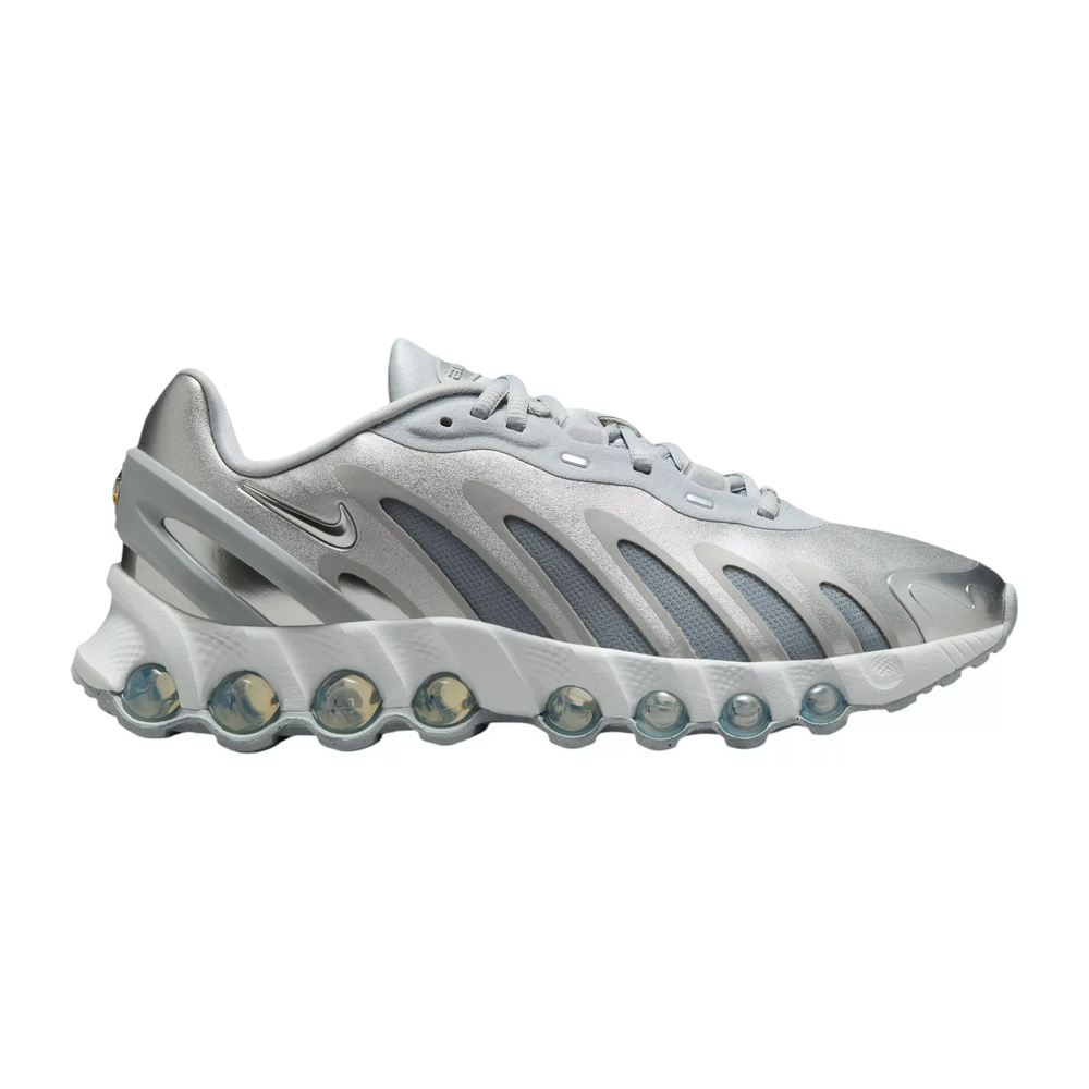 A silver Nike sneaker with a futuristic design features multiple visible air pods in the sole and the iconic swoosh logo.
