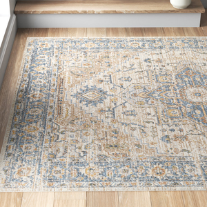Machine-washable area rug with an 8' x 10' size, featuring a vintage-inspired design in beige, blue, and gold tones, set on a light background with intricate geometric and floral patterns.