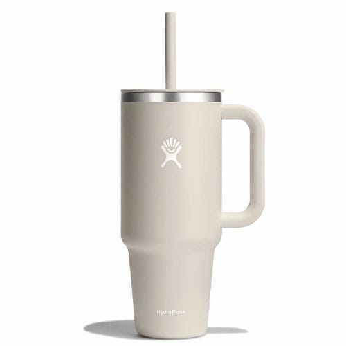 Beige Hydro Flask tumbler with a handle, lid, and straw, featuring the brand's logo.