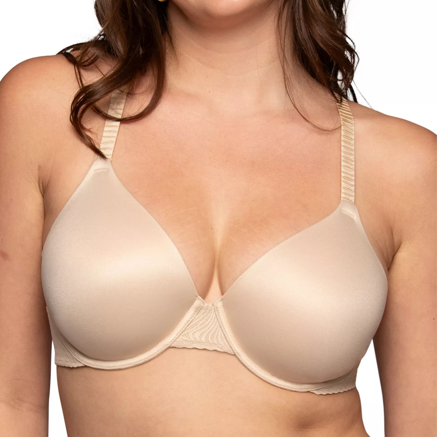 A woman wears a nude-colored, full-coverage bra with smooth cups and adjustable straps.