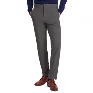 Michael Kors dress pants in a slim fit style are gray, featuring side pockets and belt loops. They are paired with brown dress shoes and a navy top.