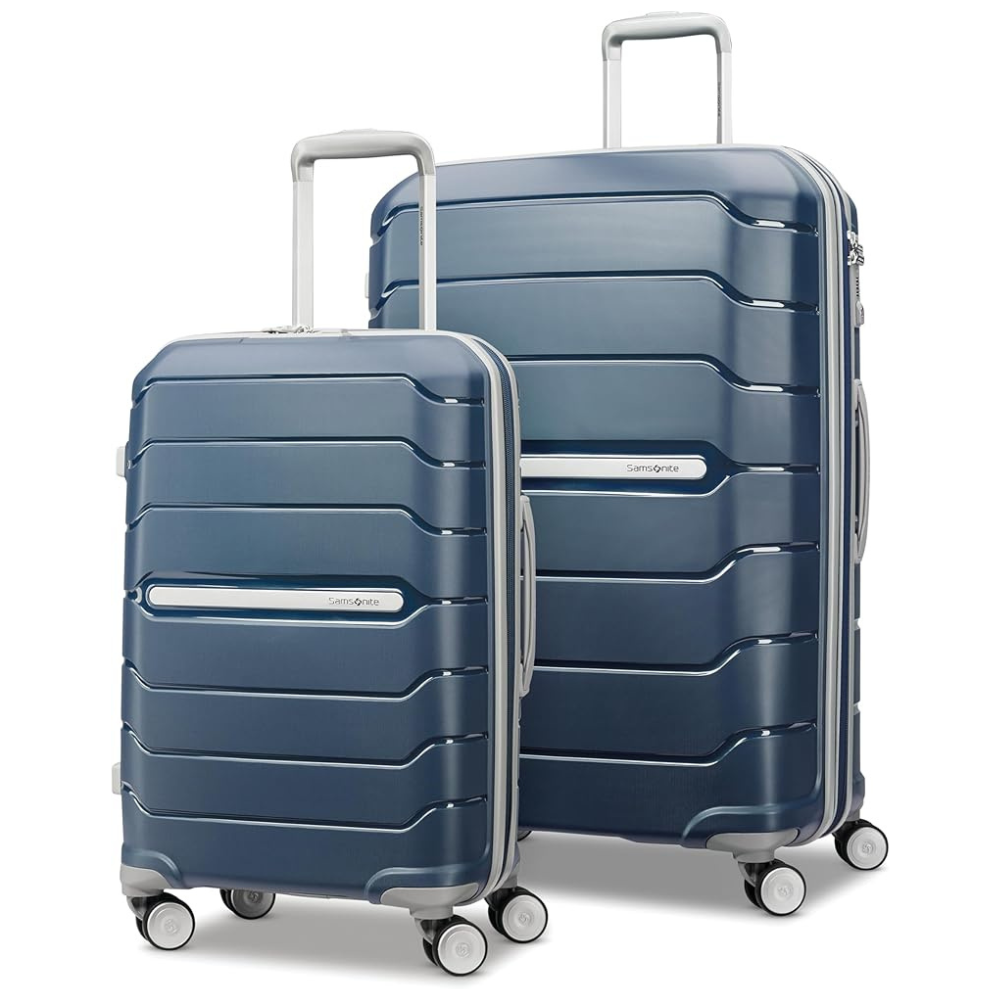 Two blue hard-shell suitcases with horizontal ridges, featuring telescopic handles and four wheels each. The smaller suitcase is placed in front of the larger one.