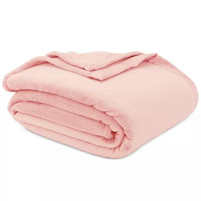 A soft, folded pink fleece blanket, neatly stacked, highlighting its plush texture and warmth.