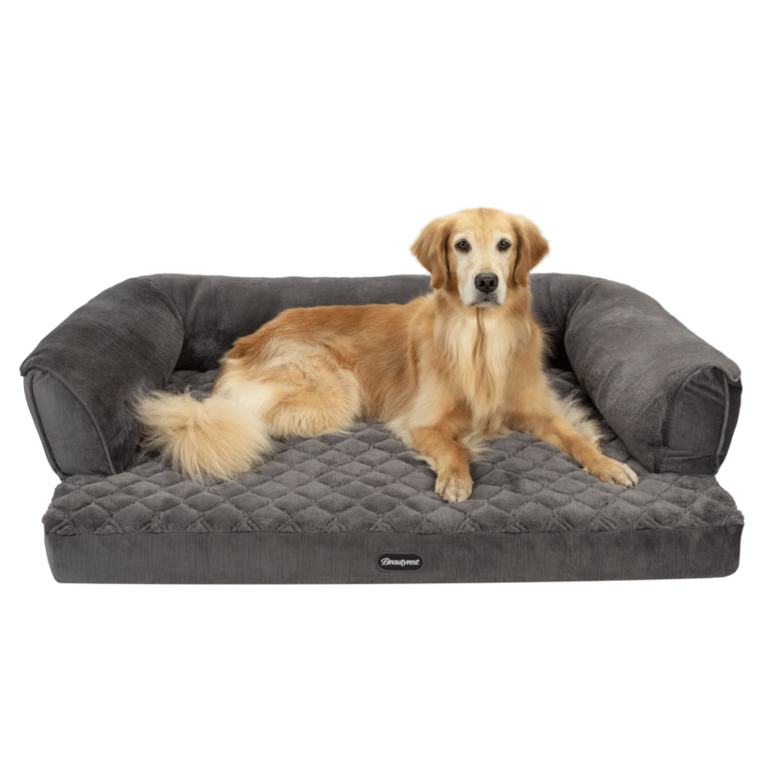A golden retriever lies on a plush, quilted dog bed with bolster sides, featuring a soft gray fabric.