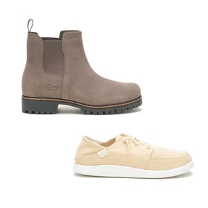 A pair of brown Chelsea boots with elastic side panels and a rugged sole, alongside a pair of light beige canvas sneakers with laces and a white sole.
