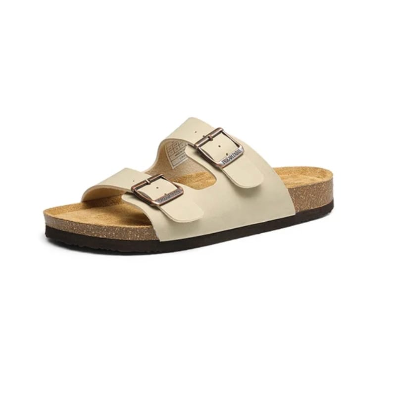 A pair of beige, double-strap sandals with adjustable metal buckles and a cork footbed.