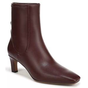 A brown leather ankle boot with a pointed toe and low block heel, featuring a minimalist design and smooth finish.