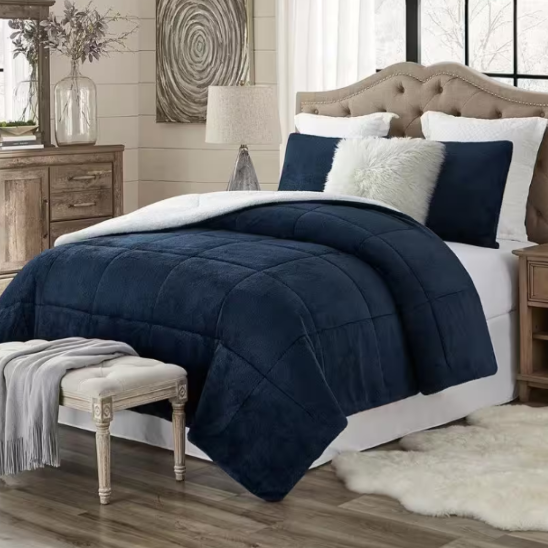 A navy blue, three-piece comforter set with a plush sherpa texture, accompanied by two matching shams, displayed on a bed with neutral-toned decor.