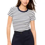 A woman wears a white and navy striped short-sleeve shirt paired with dark high-waisted pants.