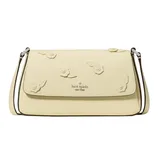 A Kate Spade New York handbag in pale yellow, featuring floral embellishments on the flap and a thin shoulder strap.
