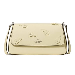 A Kate Spade New York handbag in pale yellow, featuring floral embellishments on the flap and a thin shoulder strap.