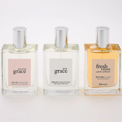 three philosophy perfumes on a grey background