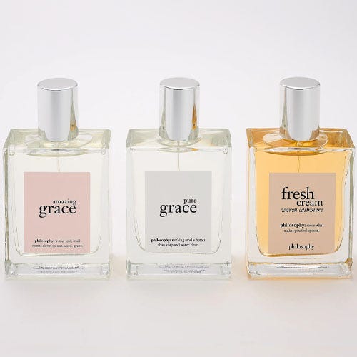 three philosophy perfumes on a grey background