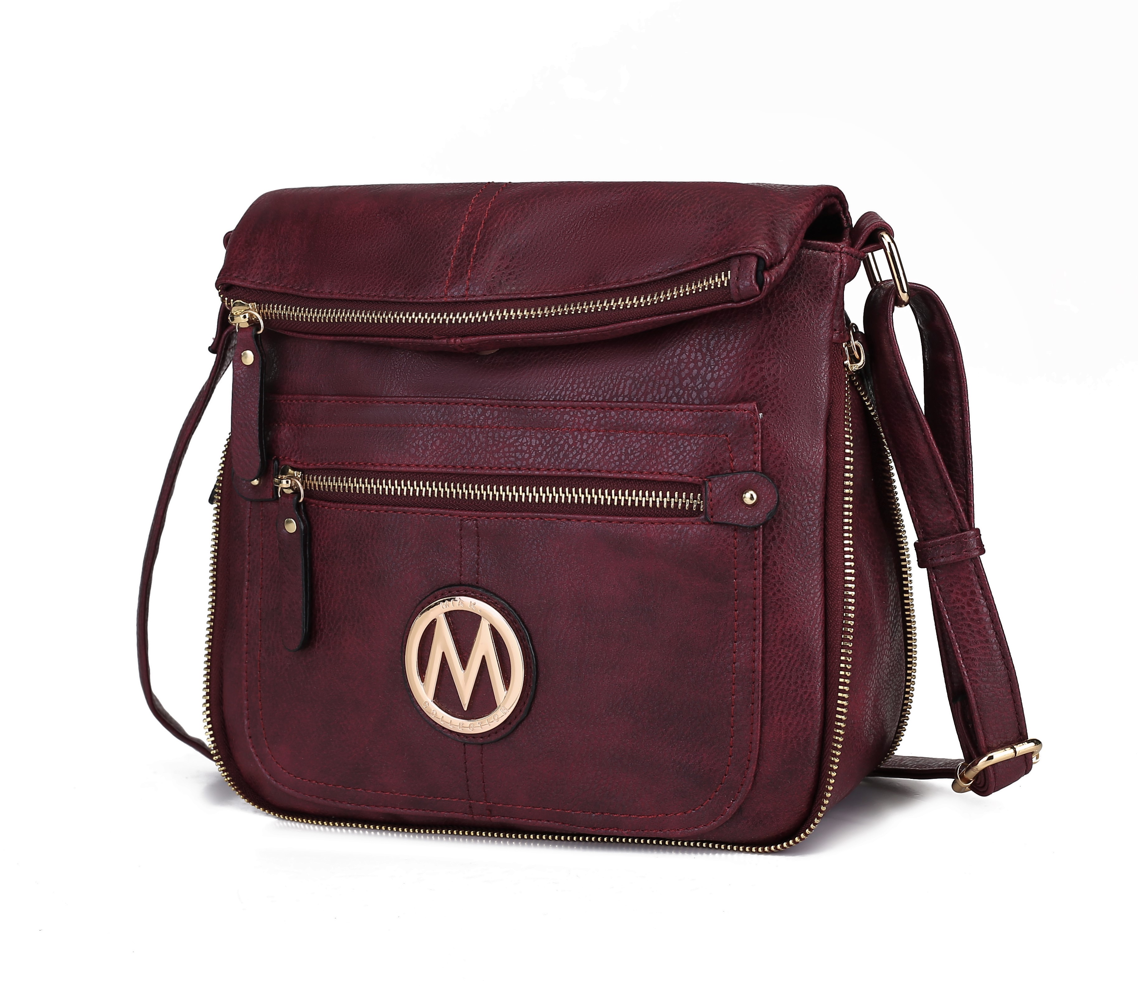 Burgundy leather crossbody bag featuring gold zippers and an adjustable strap, with a circular emblem displaying the letter \“M\“ on the front pocket.
