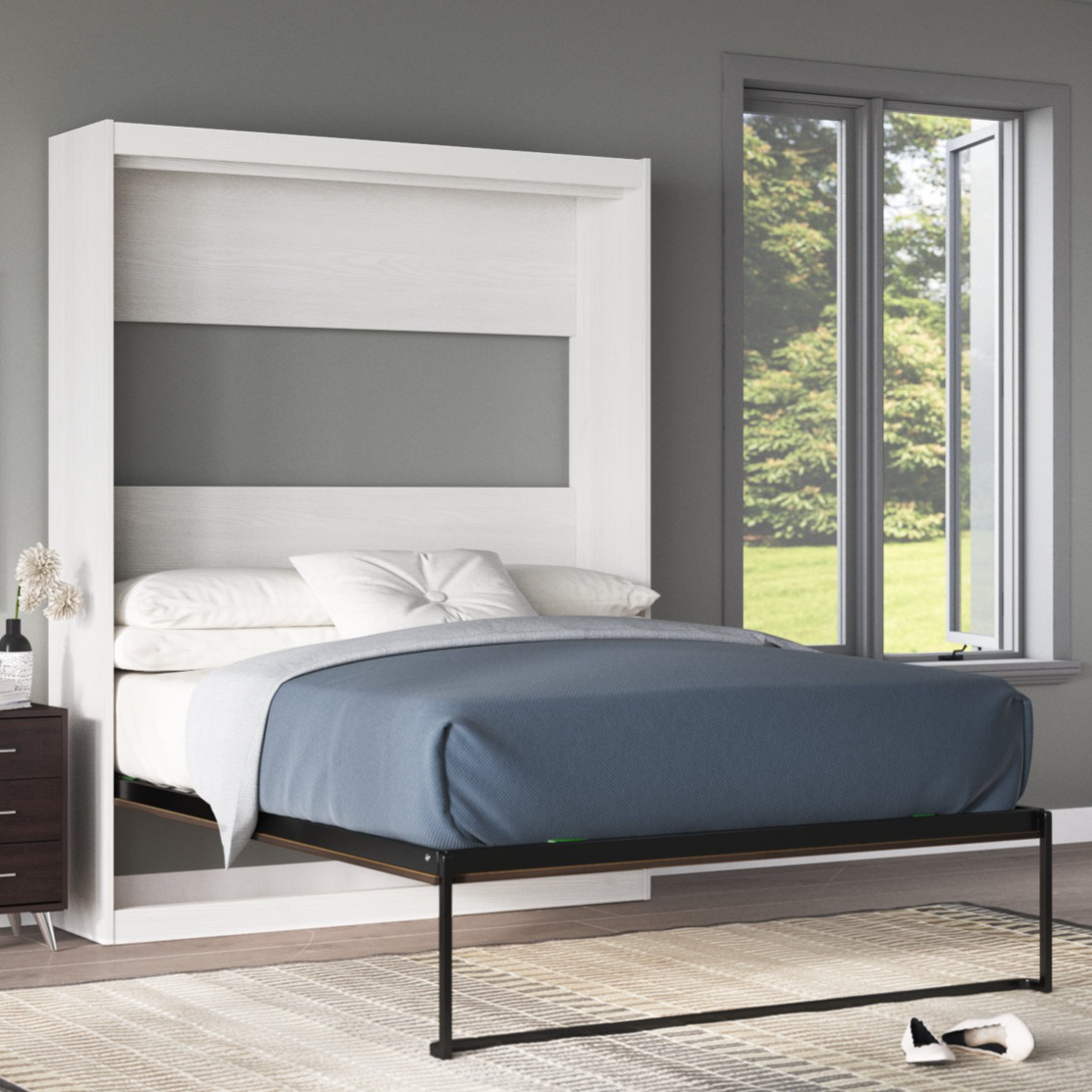 A wall-mounted Murphy bed with a white frame and black metal legs, featuring blue bedding. The bed is shown in a modern room with gray walls, a window, and a dark wooden nightstand.