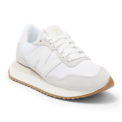 White New Balance 237 sneakers with a large 'N' logo on the side, a beige sole, and a gum rubber outsole.