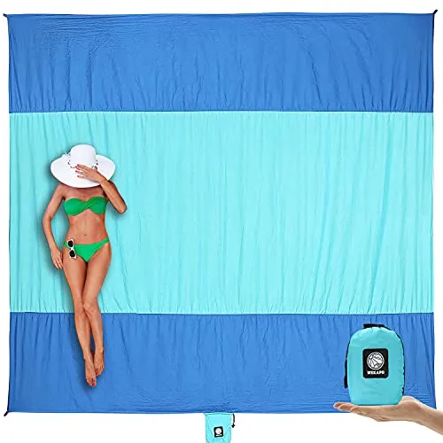Large blue and turquoise beach blanket with a person sunbathing and a small matching backpack for easy carrying.