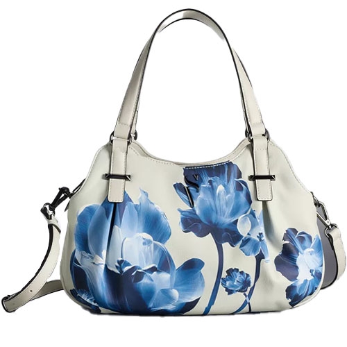 A white handbag featuring a blue floral design, equipped with dual handles and an adjustable shoulder strap.