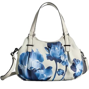 A white handbag featuring a blue floral design, equipped with dual handles and an adjustable shoulder strap.