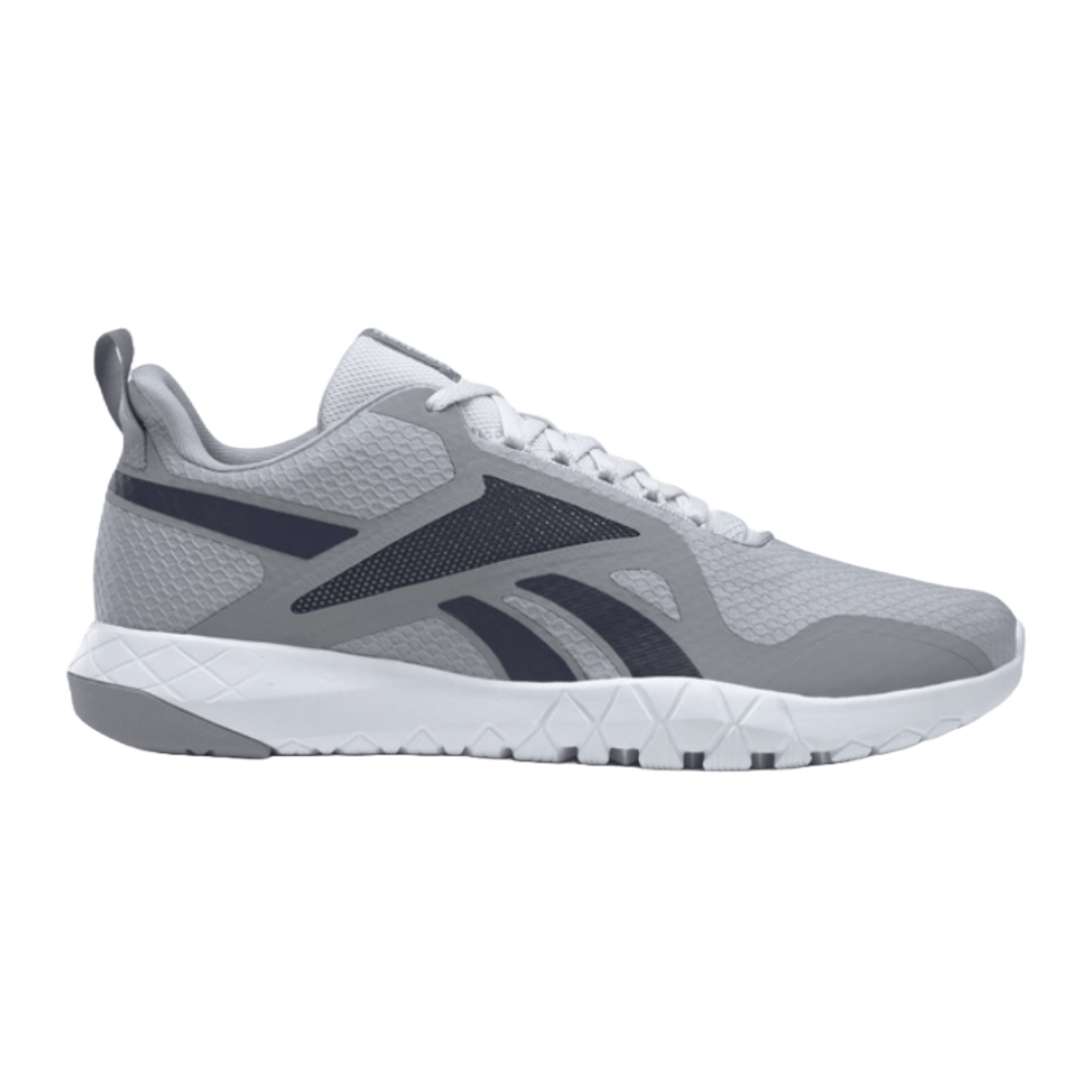 Gray training shoe with a textured mesh upper and dark accents, featuring a distinctive logo and a cushioned white sole with a hexagonal pattern for flexibility and comfort.