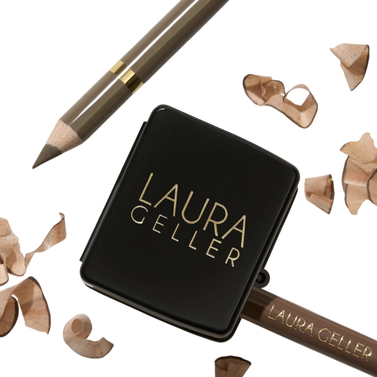 A makeup pencil from Laura Geller with a sharpener and pencil shavings.