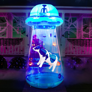 An inflatable Halloween decoration features a blue UFO with an alien and a cow, surrounded by Halloween motifs like skeletons and pumpkins.